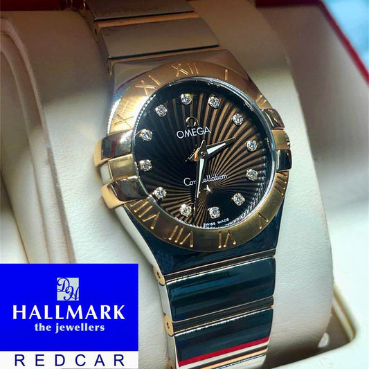 Luxury watch with diamond accents on a white cushion Omega Constellation