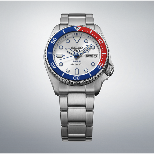 Silver watch with a red and blue bezel on a gray background